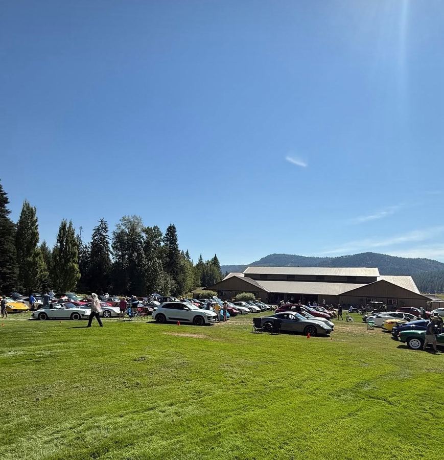 Rows of Porsches parked on the grass field at Stillwater Ranch